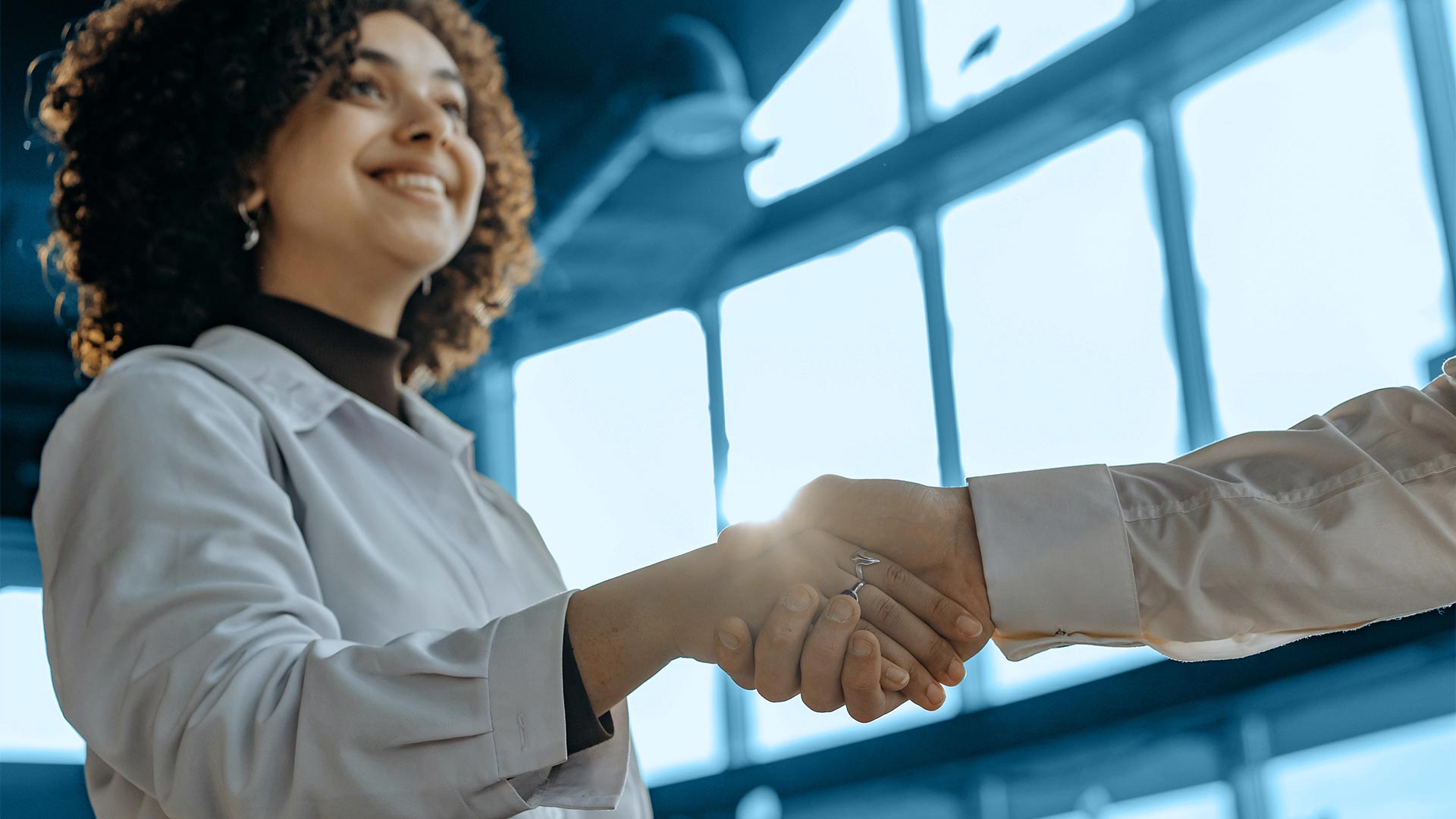 Zwei Personen geben sich zur Begrüßung die Hand